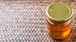 Honey,In,A,Mason,Jar,On,A,Wicker,Background